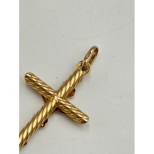 2134B - A 9ct gold crucifix pendant - approx. gross weight 2g