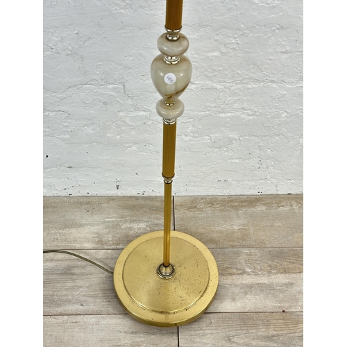 25 - A mid 20th century onyx and brass standard lamp with yellow tasselled shade - approx. 155cm high inc... 