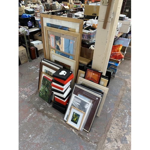 1129 - A large quantity of framed pictures and canvases