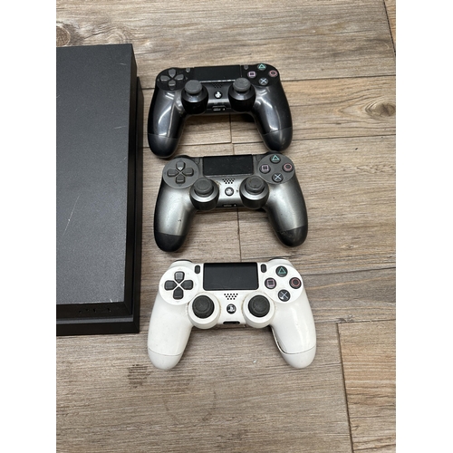 A Sony Playstation 4 with three controllers and one game