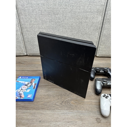 A Sony Playstation 4 with three controllers and one game
