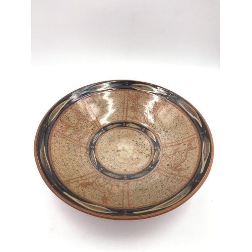 375C - A mid 20th century studio pottery circular bowl hand decorated with fish design and impressed 