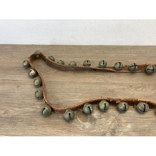 558 - A set of late/early 20th century brown leather and cast metal sleigh bells together with a vintage S... 