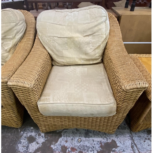 104 - A wicker four piece conservatory suite comprising two seater sofa, two armchairs and side table