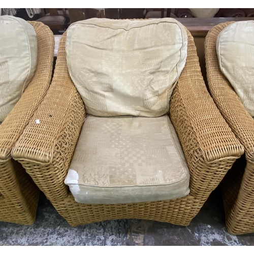 104 - A wicker four piece conservatory suite comprising two seater sofa, two armchairs and side table