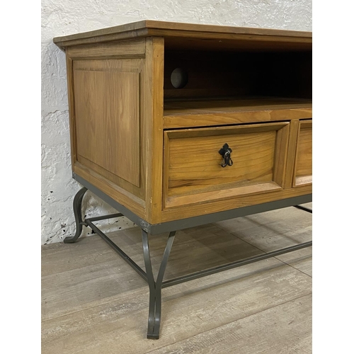 110A - A Mexican pine and wrought iron two drawer TV stand - approx. 61cm high x 80cm wide x 55cm deep