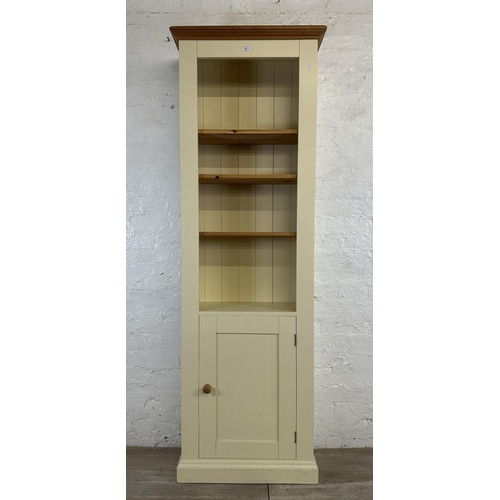 186 - A modern pine and cream painted four tier bookcase with cupboard door - approx. 197cm high x 66cm wi... 