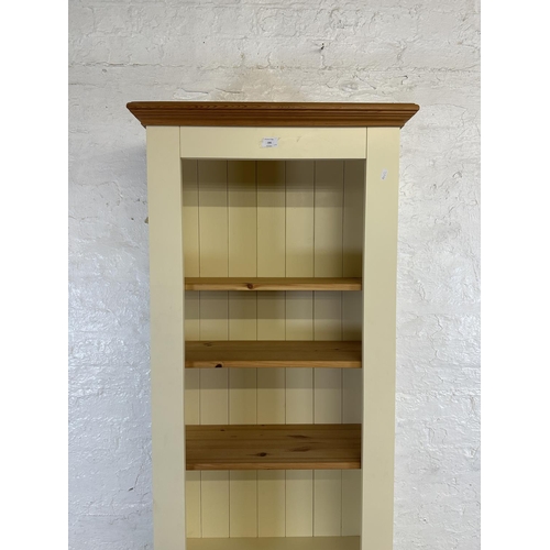 186 - A modern pine and cream painted four tier bookcase with cupboard door - approx. 197cm high x 66cm wi... 