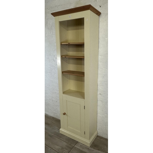 186 - A modern pine and cream painted four tier bookcase with cupboard door - approx. 197cm high x 66cm wi... 