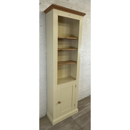 186 - A modern pine and cream painted four tier bookcase with cupboard door - approx. 197cm high x 66cm wi... 