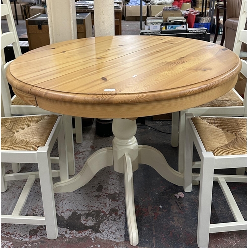 187 - A modern pine and cream painted circular extending dining table and four white painted and rush seat... 