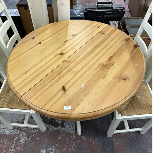 187 - A modern pine and cream painted circular extending dining table and four white painted and rush seat... 