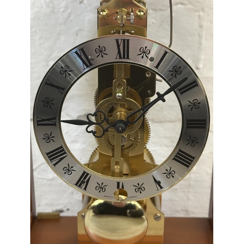 21 - A Franz Hermle & Sohn walnut effect cased key wind skeleton mantel clock with pendulum - approx. 30c... 