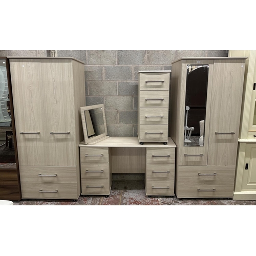 27 - A contemporary grey wood effect four piece bedroom suite comprising two double wardrobes, chest of d... 