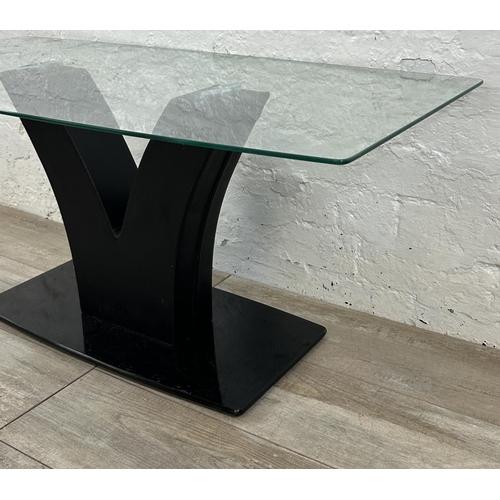 36 - A contemporary glass top coffee table on black faux leather and glass base - approx. 45cm high x 50c... 