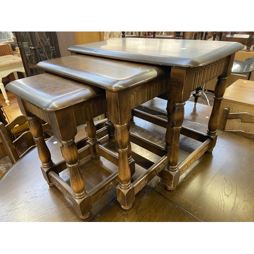 64 - Three pieces of Priory carved oak furniture, one circular side table, one rectangular side table and... 