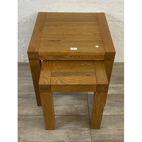 68 - A contemporary solid oak nest of two tables - approx. 50cm high x 50cm wide x 50cm deep