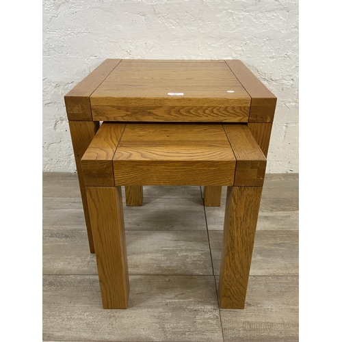 68 - A contemporary solid oak nest of two tables - approx. 50cm high x 50cm wide x 50cm deep