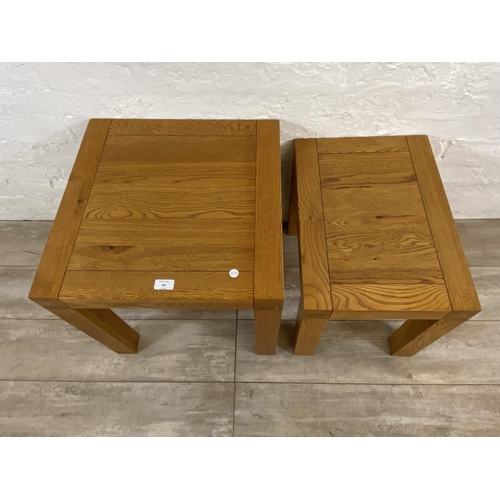 68 - A contemporary solid oak nest of two tables - approx. 50cm high x 50cm wide x 50cm deep