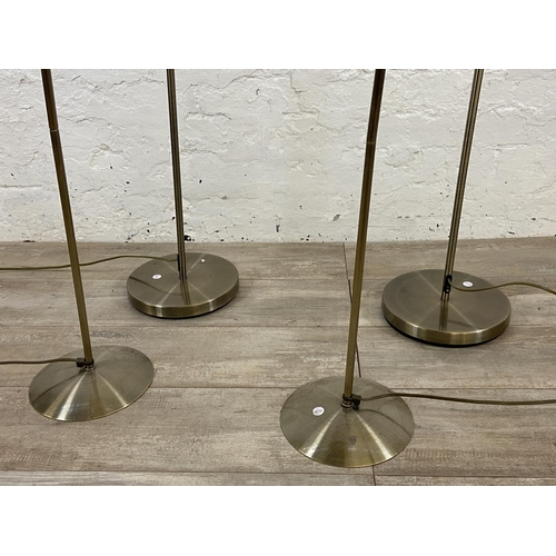 71 - Four contemporary brass effect floor lamps, two B&Q and two Massive