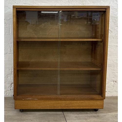 81 - A mid 20th century teak bookcase with two glass sliding doors - approx. 81cm high x 68cm wide x 28cm... 