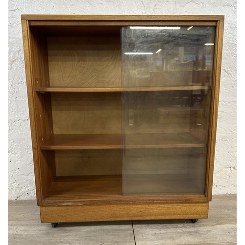 81 - A mid 20th century teak bookcase with two glass sliding doors - approx. 81cm high x 68cm wide x 28cm... 