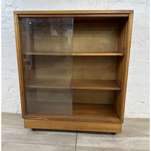 81 - A mid 20th century teak bookcase with two glass sliding doors - approx. 81cm high x 68cm wide x 28cm... 