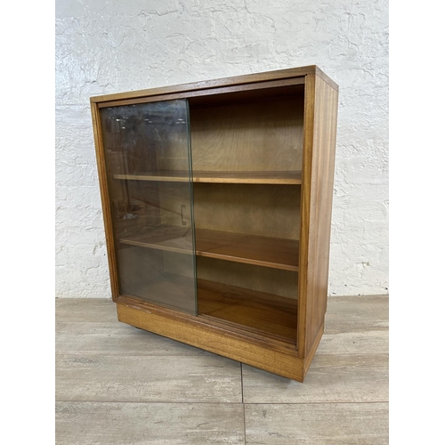 81 - A mid 20th century teak bookcase with two glass sliding doors - approx. 81cm high x 68cm wide x 28cm... 