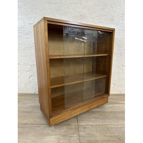 81 - A mid 20th century teak bookcase with two glass sliding doors - approx. 81cm high x 68cm wide x 28cm... 