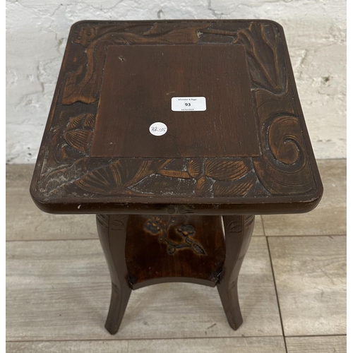 93 - An Arts and Crafts style carved hardwood two tier side table in the manner of Liberty & Co - approx.... 