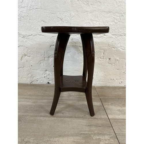 93 - An Arts and Crafts style carved hardwood two tier side table in the manner of Liberty & Co - approx.... 