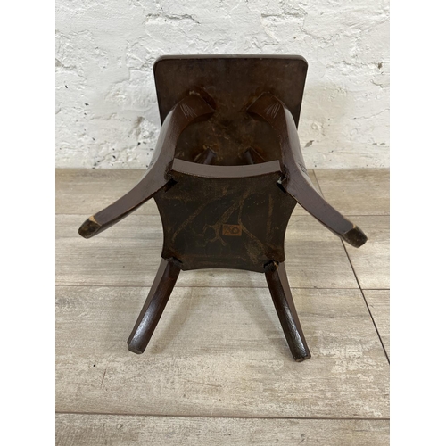 93 - An Arts and Crafts style carved hardwood two tier side table in the manner of Liberty & Co - approx.... 