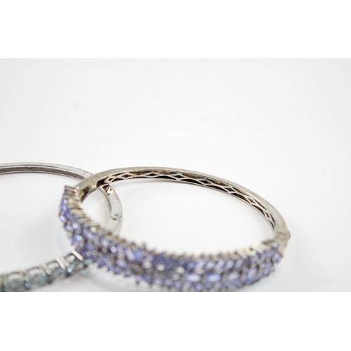 2066 - Two sterling silver gemstone bangles, one tanzanite and one topaz - approx. gross weight 37g