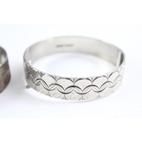 2068 - Two sterling silver bangles, one mid century and one etched - approx. gross weight 71g