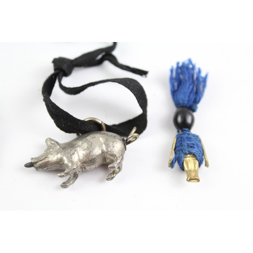 2115 - Three pieces of jewellery, one Touch Wud charm, one white metal hand brooch and one white metal pig ... 