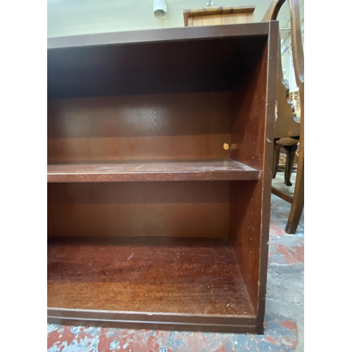 82 - A mahogany effect two tier bookcase - approx. 63cm high x 90cm wide x 35cm deep