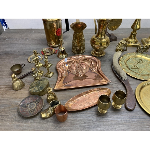 292 - A collection of metalware to include Arts and Crafts copper crumb brush and tray, pair of brass cand... 