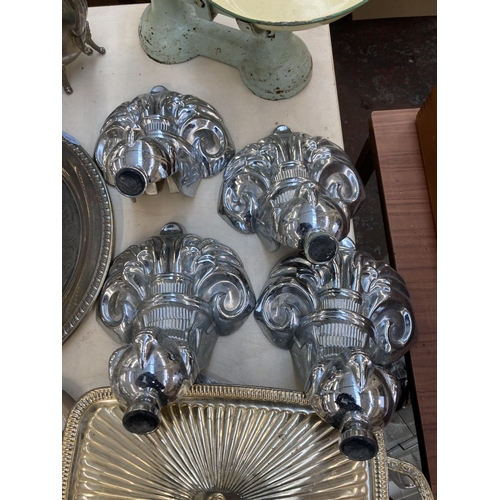 305 - A collection of metalware to include four Victorian style chrome plated bath feet, three silver plat... 