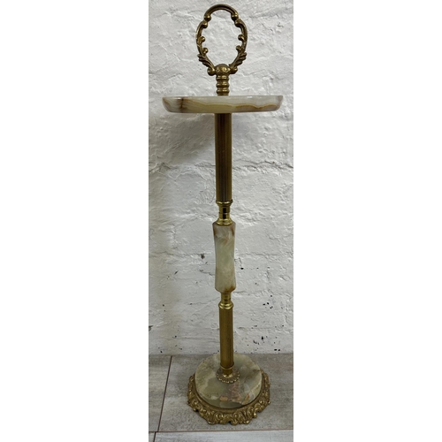 16 - Four onyx and gilt metal items, three candelabras and one floor standing ashtray - approx. 64cm high