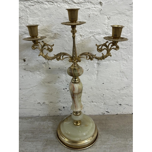 16 - Four onyx and gilt metal items, three candelabras and one floor standing ashtray - approx. 64cm high