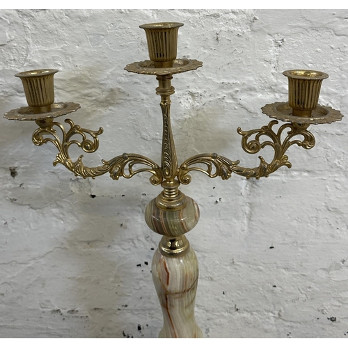 16 - Four onyx and gilt metal items, three candelabras and one floor standing ashtray - approx. 64cm high