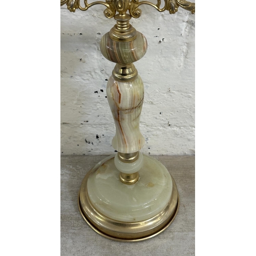 16 - Four onyx and gilt metal items, three candelabras and one floor standing ashtray - approx. 64cm high