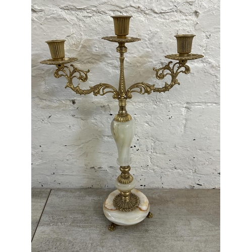 16 - Four onyx and gilt metal items, three candelabras and one floor standing ashtray - approx. 64cm high