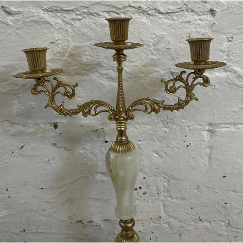 16 - Four onyx and gilt metal items, three candelabras and one floor standing ashtray - approx. 64cm high