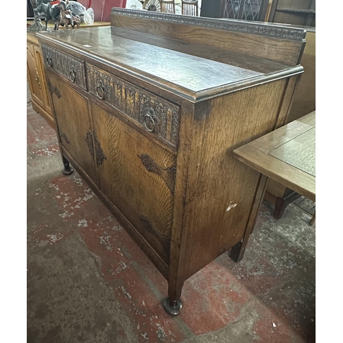 169 - An early 20th century carved oak sideboard - approx. 104cm high x 122cm wide x 47cm deep