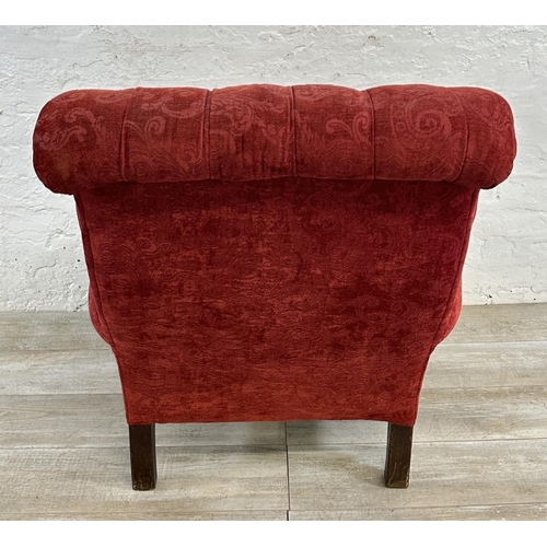 180 - A Victorian red fabric button back upholstered armchair on mahogany supports and castors - approx. 9... 