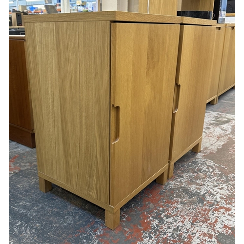 183 - A pair of modern oak effect single door cabinets - approx. 74cm high x 43cm wide x 42cm deep