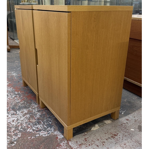 183 - A pair of modern oak effect single door cabinets - approx. 74cm high x 43cm wide x 42cm deep