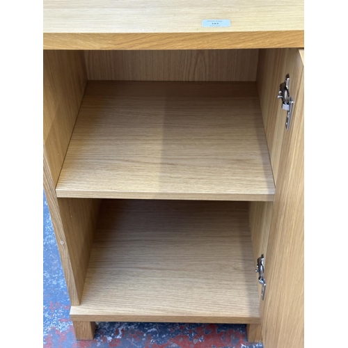 183 - A pair of modern oak effect single door cabinets - approx. 74cm high x 43cm wide x 42cm deep