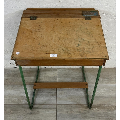 22 - A mid 20th century beech and plywood child's school desk on green painted tubular metal stand - appr... 